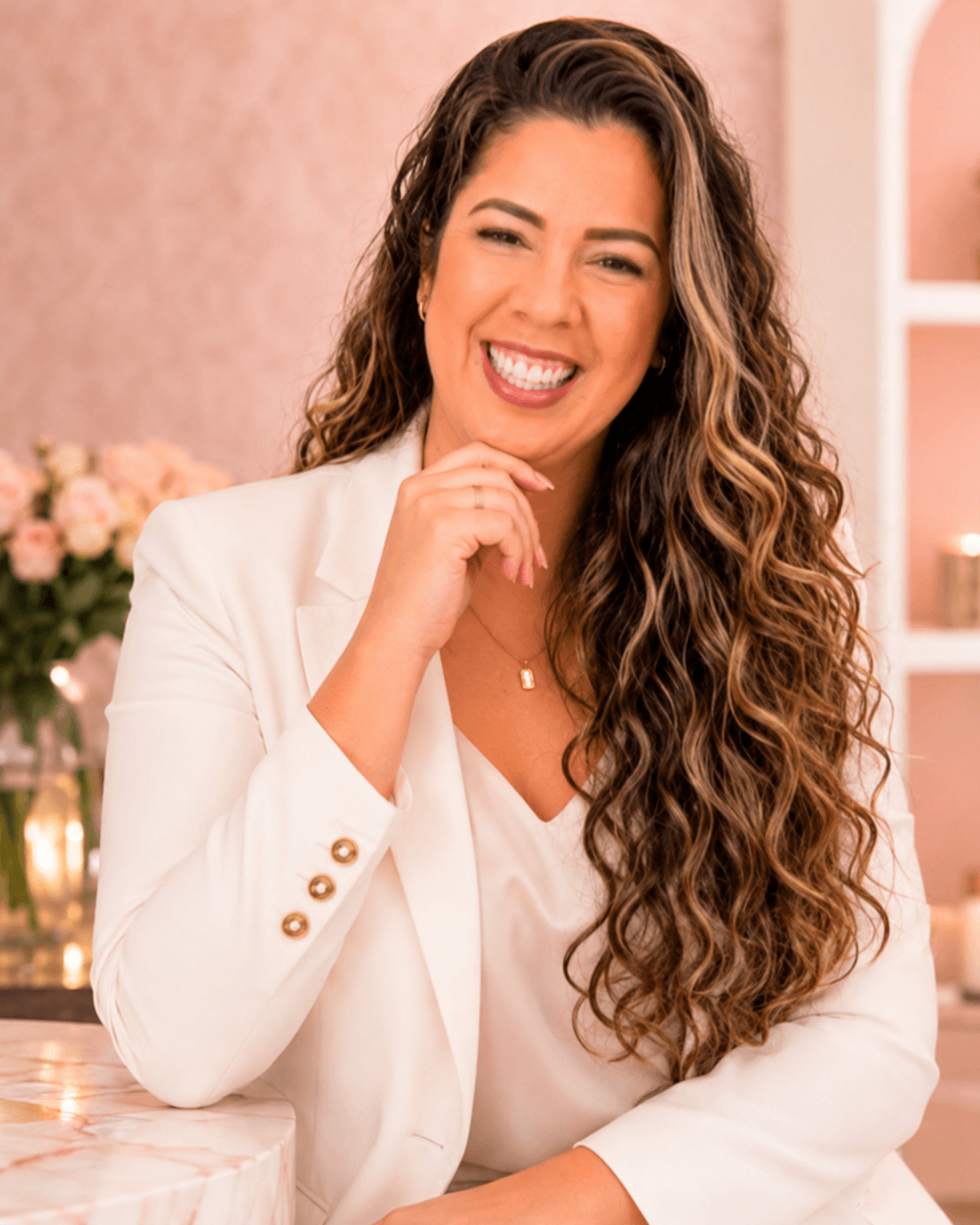Lais Barbosa, consultora de beleza Mary Kay, sorrindo em ambiente decorado com flores.